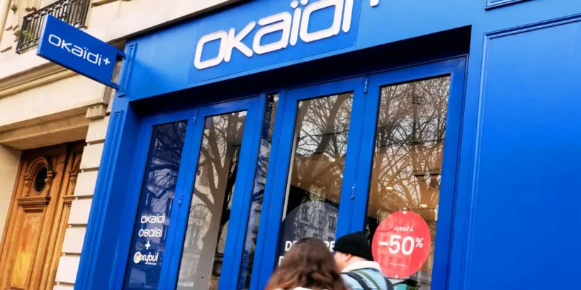 Devanture d’un magasin Okaïdi avec des clients et des affiches de liquidation en France.