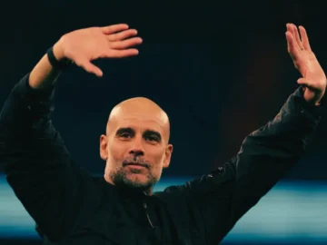 Pep Guardiola concentré sur le banc de Manchester City pendant un match sous pression.