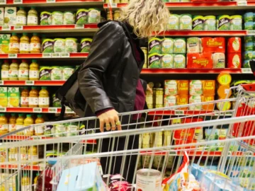 Des clients comparent les prix dans un supermarché français confronté à l’inflation alimentaire.
