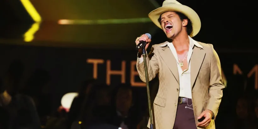 Bruno Mars chante sur scène sous les projecteurs lors d’un concert événement célébrant son retour en France.