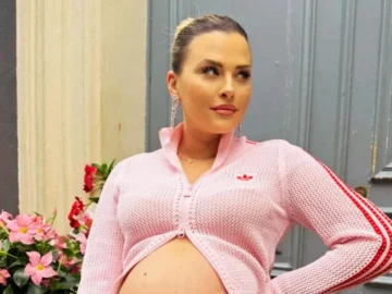 Kelly Vedovelli tenant les petits pieds de ses jumelles Céleste et Esmée